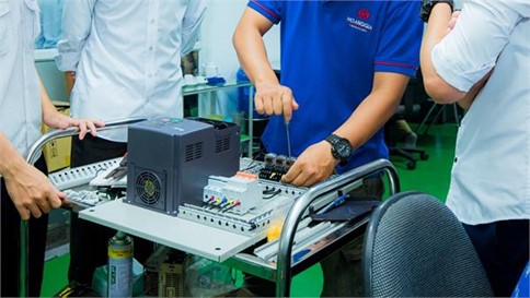 Kỹ sư hướng dẫn đấu nối biến tần và tủ điều khiển trên bàn kỹ thuật